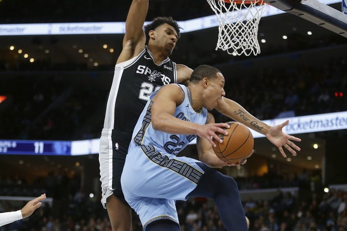 Jan 2, 2024; Memphis, Tennessee, USA; Memphis Grizzlies guard Desmond Bane (22) passes the ball as San Antonio Spurs forward Dominick Barlow (26) defends during the first half at FedExForum.