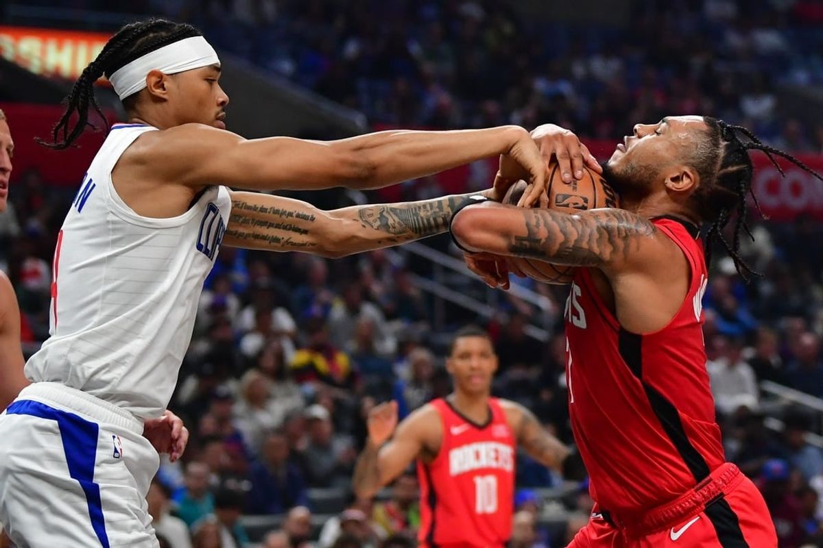 Apr 14, 2024; Los Angeles, California, USA; Los Angeles Clippers guard Brandon Boston Jr. (4) reaches for the ball against Houston Rockets forward Cam Whitmore (7) during the first half at Crypto.com Arena.