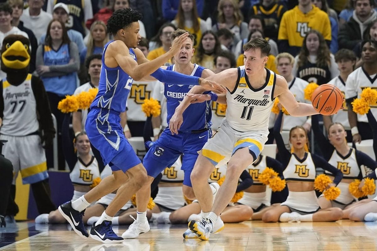 Dec 30, 2023; Milwaukee, Wisconsin, USA;  Marquette Golden Eagles guard Tyler Kolek (11) looks to pass the ball while under pressure from Creighton Bluejays guard Trey Alexander (23) during the first half at Fiserv Forum.