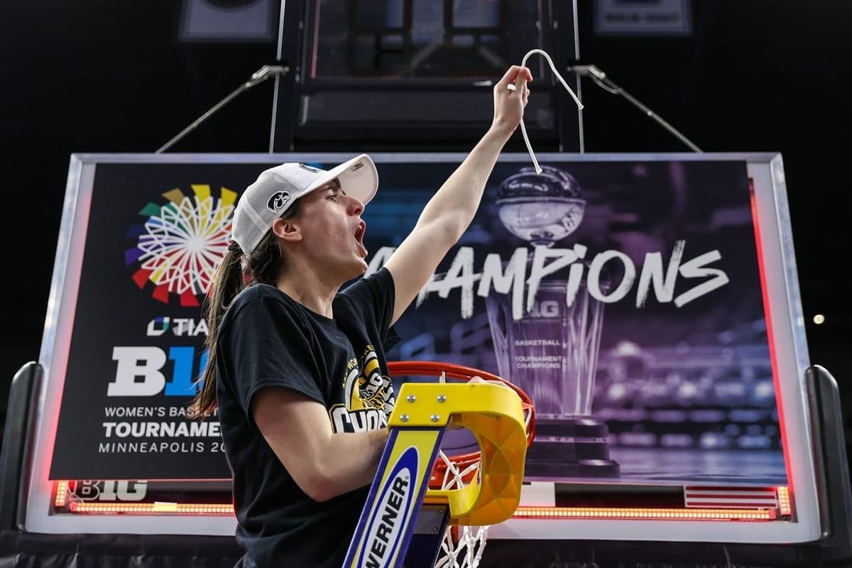 Mar 10, 2024; Minneapolis, MN, USA; Iowa Hawkeyes guard Caitlin Clark (22) cuts a piece off the net after the game against the Nebraska Cornhuskers at Target Center.