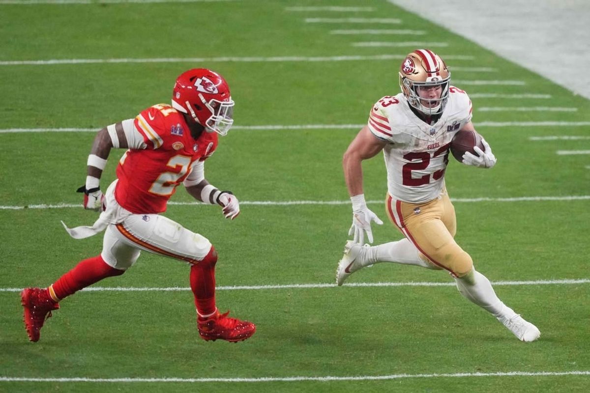 Feb 11, 2024; Paradise, Nevada, USA; San Francisco 49ers running back Christian McCaffrey (23) runs with the ball against Kansas City Chiefs safety Mike Edwards (21) during overtime of Super Bowl LVIII at Allegiant Stadium.