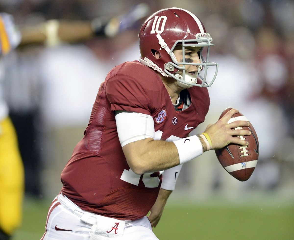 Nov 9, 2013; Tuscaloosa, AL, USA; Alabama Crimson Tide quarterback AJ McCarron (10) runs with the ball against the LSU Tigers during the third quarter at Bryant-Denny Stadium. Mandatory Credit: John David Mercer-Imagn Images