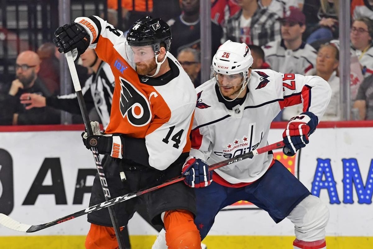 Apr 16, 2024; Philadelphia, Pennsylvania, USA; Philadelphia Flyers center Sean Couturier (14) and Washington Capitals center Nic Dowd (26) battle for position during the second period at Wells Fargo Center.