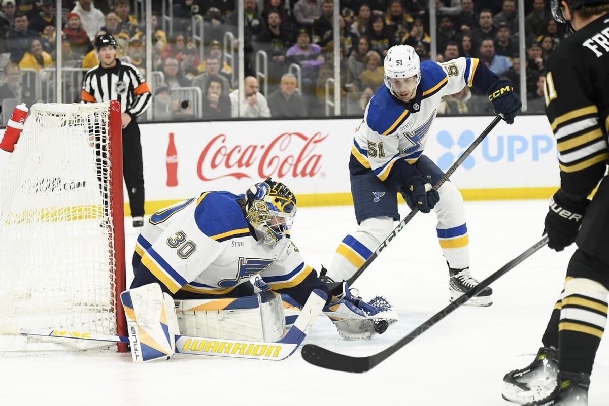 Mar 11, 2024; Boston, Massachusetts, USA;  St. Louis Blues goaltender Joel Hofer (30) gathers the puck in front of St. Louis Blues defenseman Matthew Kessel (51) during the first period against the Boston Bruins at TD Garden.