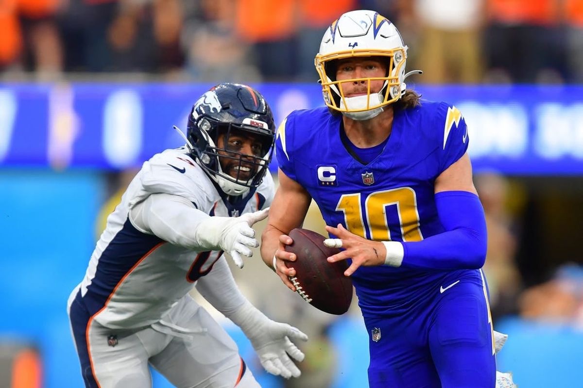 Dec 10, 2023; Inglewood, California, USA; Los Angeles Chargers quarterback Justin Herbert (10) moves out to pass against the defense of Denver Broncos linebacker Jonathon Cooper (0) during the first half at SoFi Stadium.