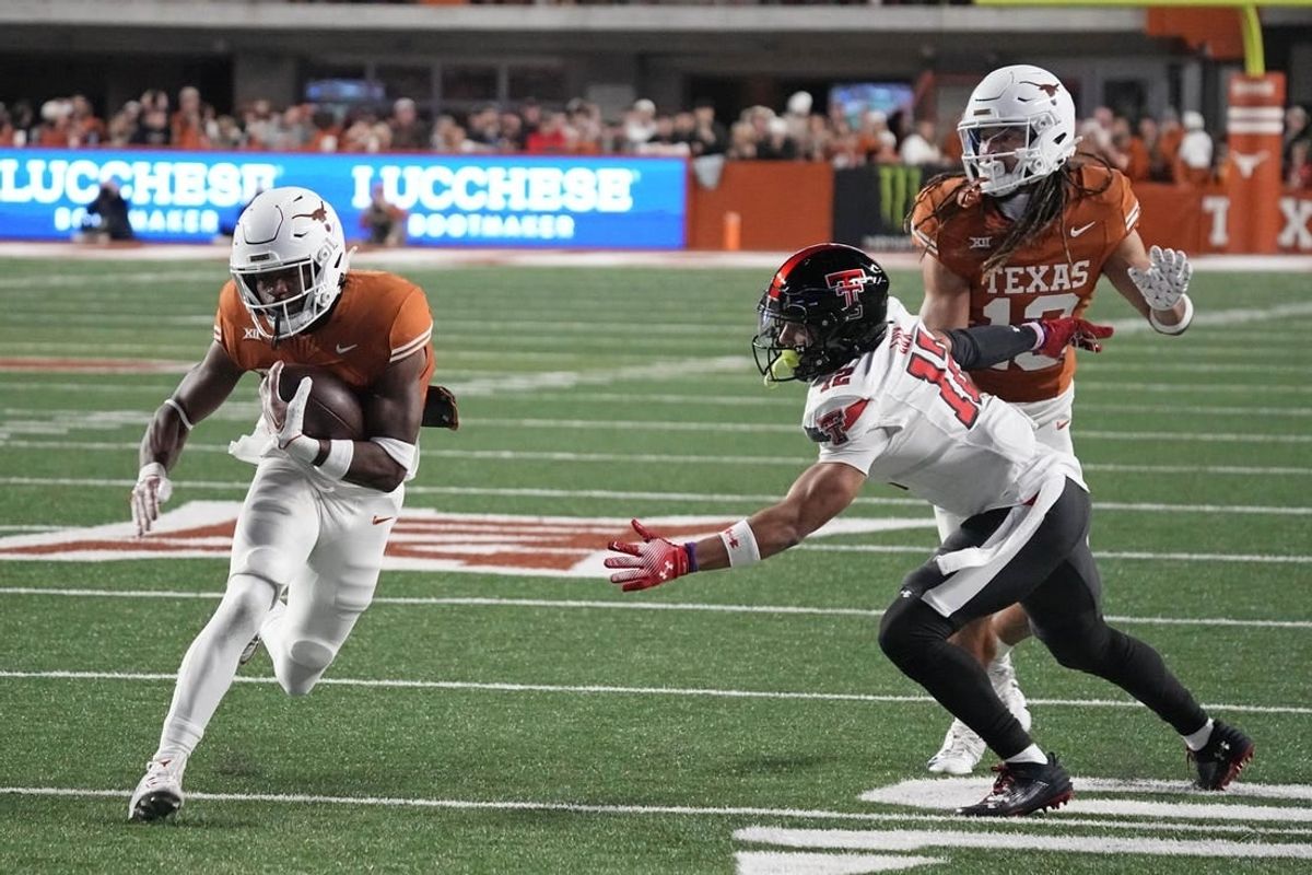 Nov 24, 2023; Austin, Texas, USA; Texas Longhorns running back Keilan Robinson (7) runs for a touchdown while defended by Texas Tech Red Raiders defensive back Bralyn Lux (12) during the first half at Darrell K Royal-Texas Memorial Stadium.