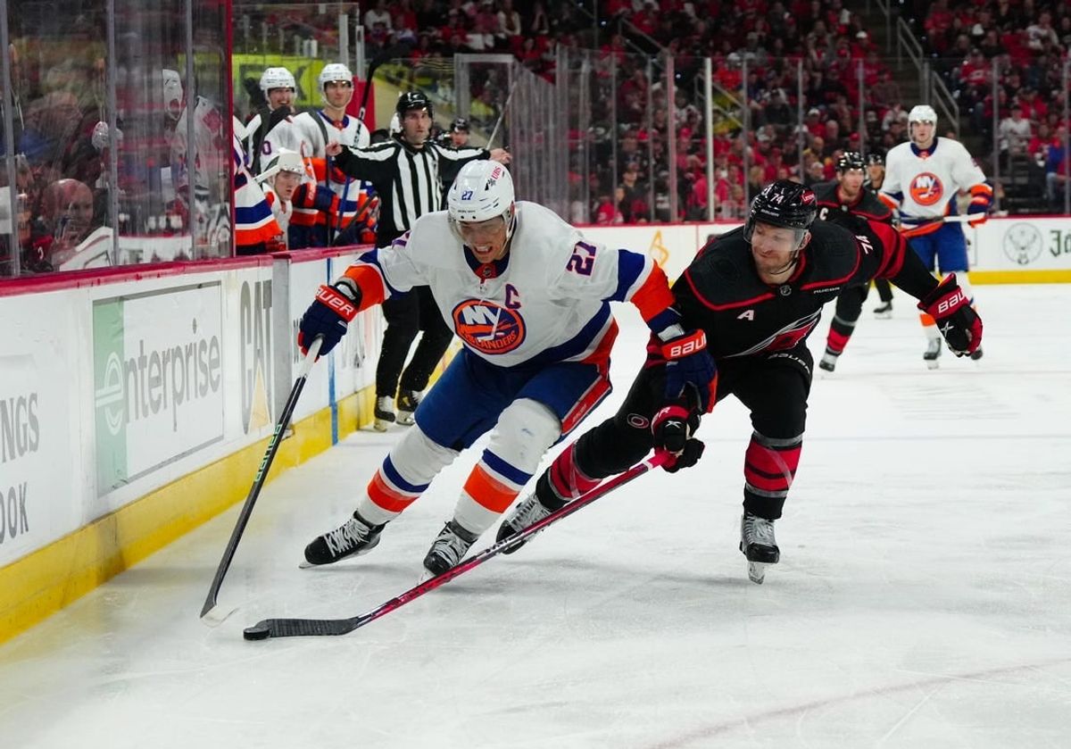 Apr 20, 2024; Raleigh, North Carolina, USA; New York Islanders center Kyle Palmieri (21) skates with the puck outside of Carolina Hurricanes defenseman Jaccob Slavin (74) during the second period in game one of the first round of the 2024 Stanley Cup Playoffs at PNC Arena.