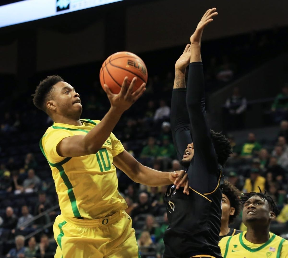 Oregon   s Kwame Evans Jr., left, shots around Kent State   s Reggie Bass during the first half at Matthew Knight Arena Thursday, Dec. 21, 2023.