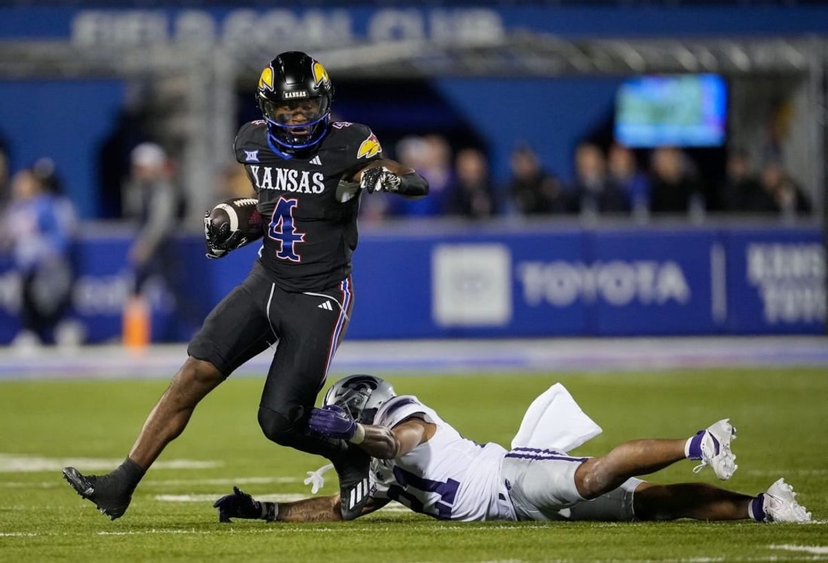 Nov 18, 2023; Lawrence, Kansas, USA; Kansas Jayhawks running back Devin Neal (4) runs the ball against Kansas State Wildcats safety Marques Sigle (21) during the first half at David Booth Kansas Memorial Stadium.