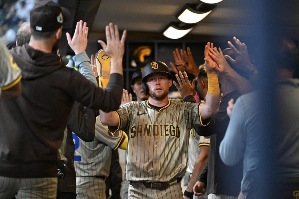 Apr 15, 2024; Milwaukee, Wisconsin, USA; San Diego Padres first base Jake Cronenworth (9) is congratulated after scoring a run against the Milwaukee Brewers in the fifth inning at American Family Field. All players wore #42 in honor of Jackie Robinson Day.