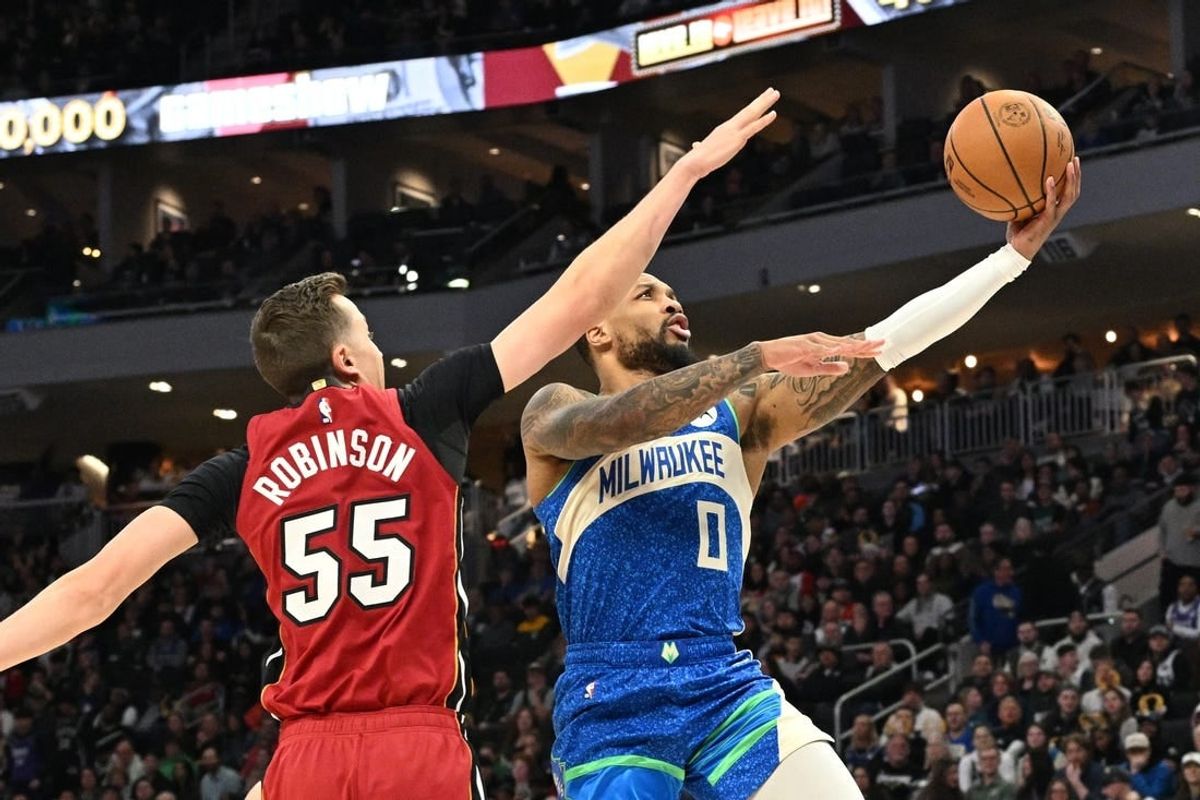 Feb 13, 2024; Milwaukee, Wisconsin, USA; Milwaukee Bucks guard Damian Lillard (0) drives to the basket against Miami Heat forward Duncan Robinson (55) in the first half at Fiserv Forum.