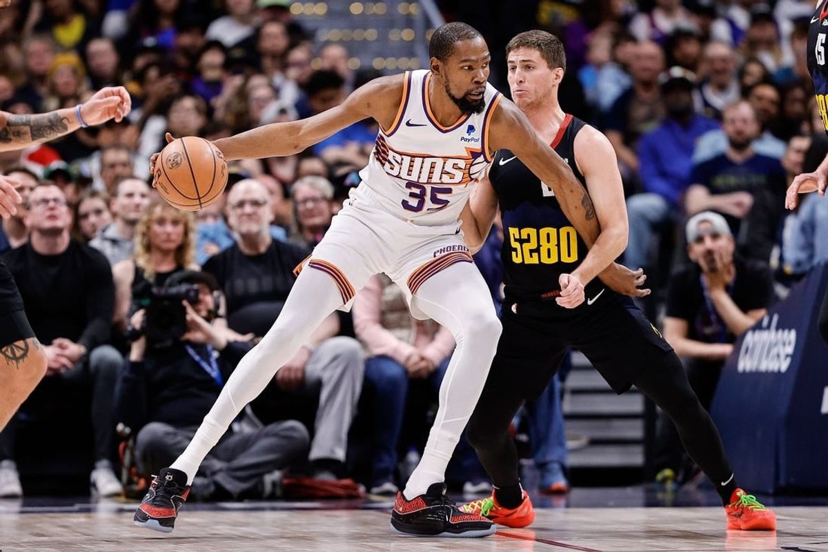 Mar 27, 2024; Denver, Colorado, USA; Phoenix Suns forward Kevin Durant (35) controls the ball as Denver Nuggets guard Collin Gillespie (21) guards in the second quarter at Ball Arena.