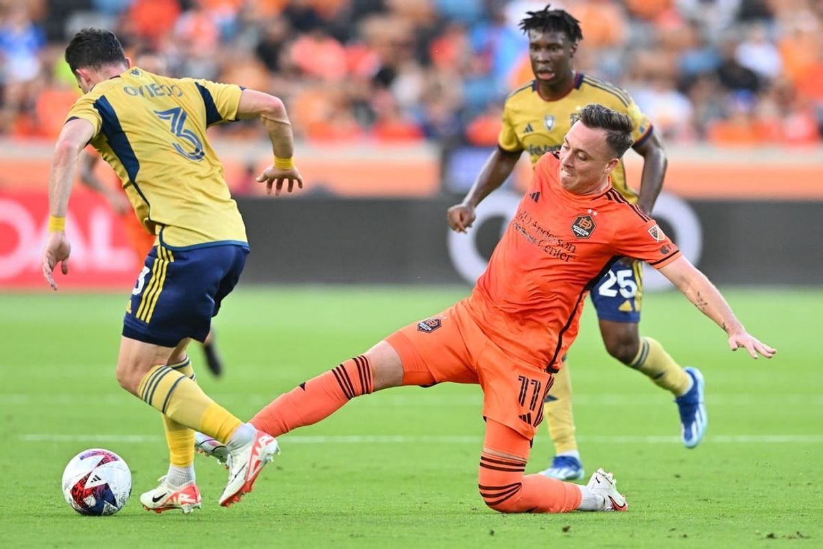 Oct 29, 2023; Houston, TX, USA; Houston Dynamo forward Corey Baird (11) kicks the bal from Real Salt Lake defender Bryan Oviedo (3) in the first half for game one in a round one match of the 2023 MLS Cup Playoffs at Shell Energy Stadium.