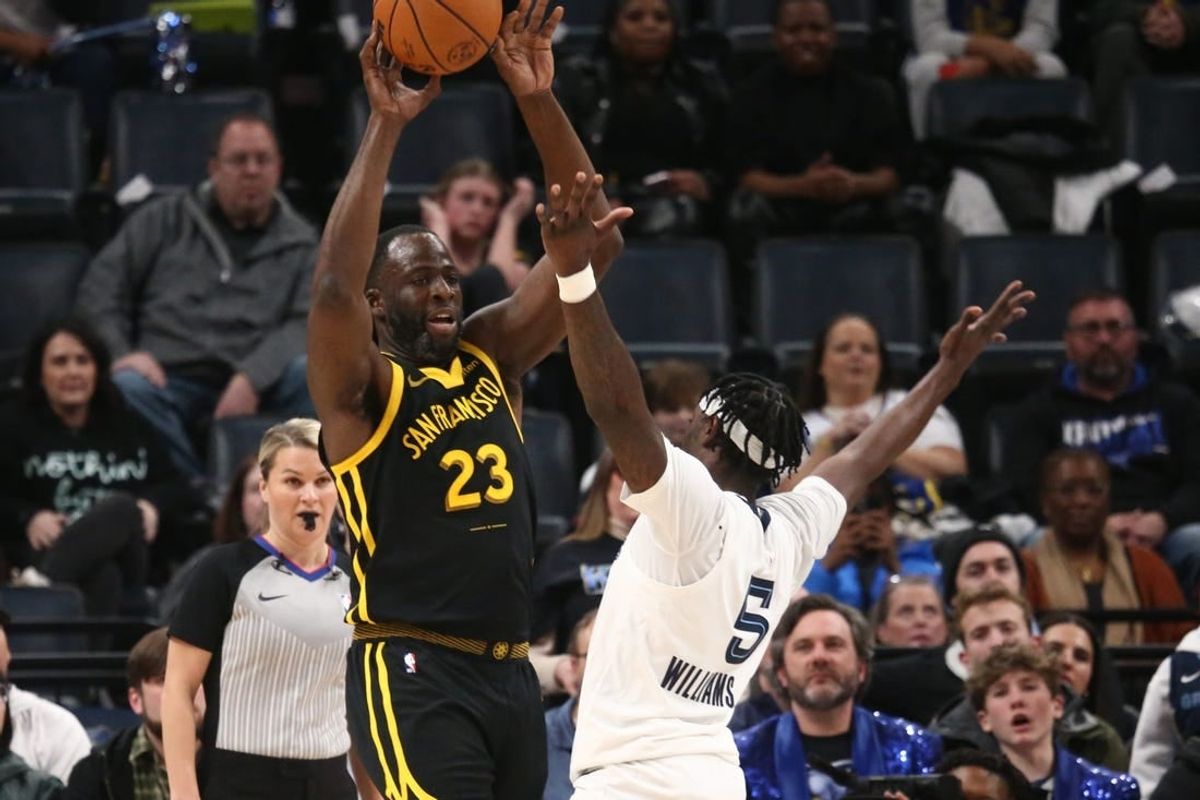 Jan 15, 2024; Memphis, Tennessee, USA; Golden State Warriors forward Draymond Green (23) passes the ball as Memphis Grizzlies guard Vince Williams Jr. (5) defends during the first half at FedExForum.
