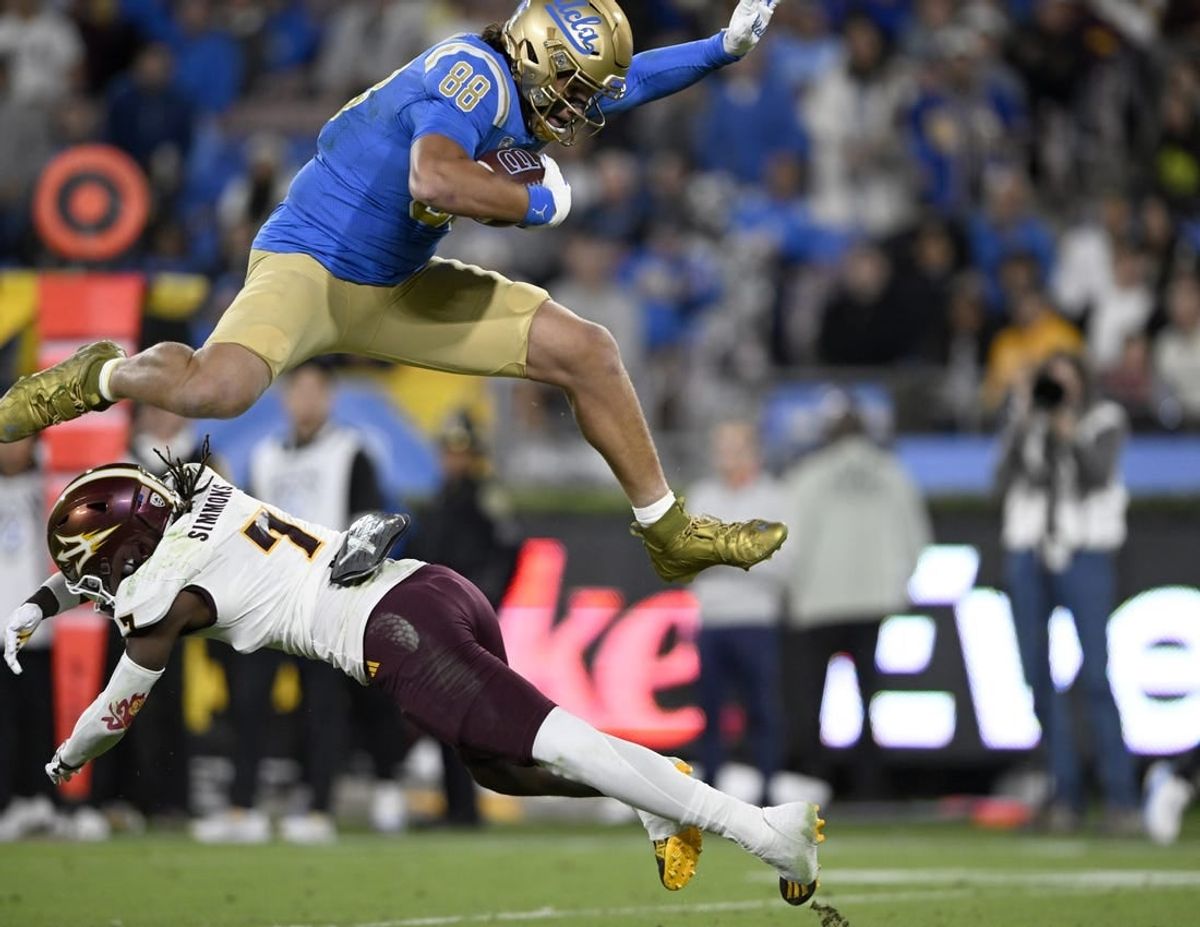Nov 11, 2023; Pasadena, California, USA;  UCLA Bruins tight end Moliki Matavao (88) leaps over Arizona State Sun Devils defensive back Shamari Simmons (7) after making a catch during the first half at the Rose Bowl.