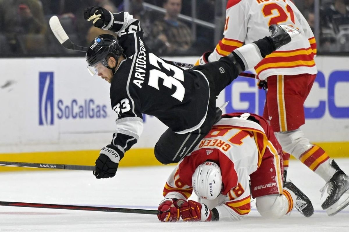 Apr 11, 2024; Los Angeles, California, USA;  Los Angeles Kings right wing Viktor Arvidsson (33) is tripped up by Calgary Flames left wing A.J. Greer (18) in the first period at Crypto.com Arena.