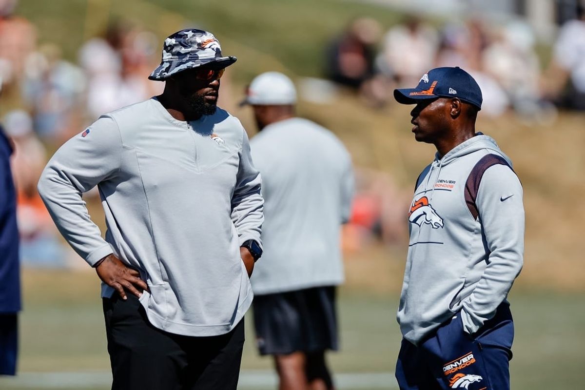 Aug 10, 2022; Englewood, CO, USA; Denver Broncos defensive line coach Marcus Dixon (L) talks with defensive coordinator Ejiro Evero (R) during training camp at the UCHealth Training Center.