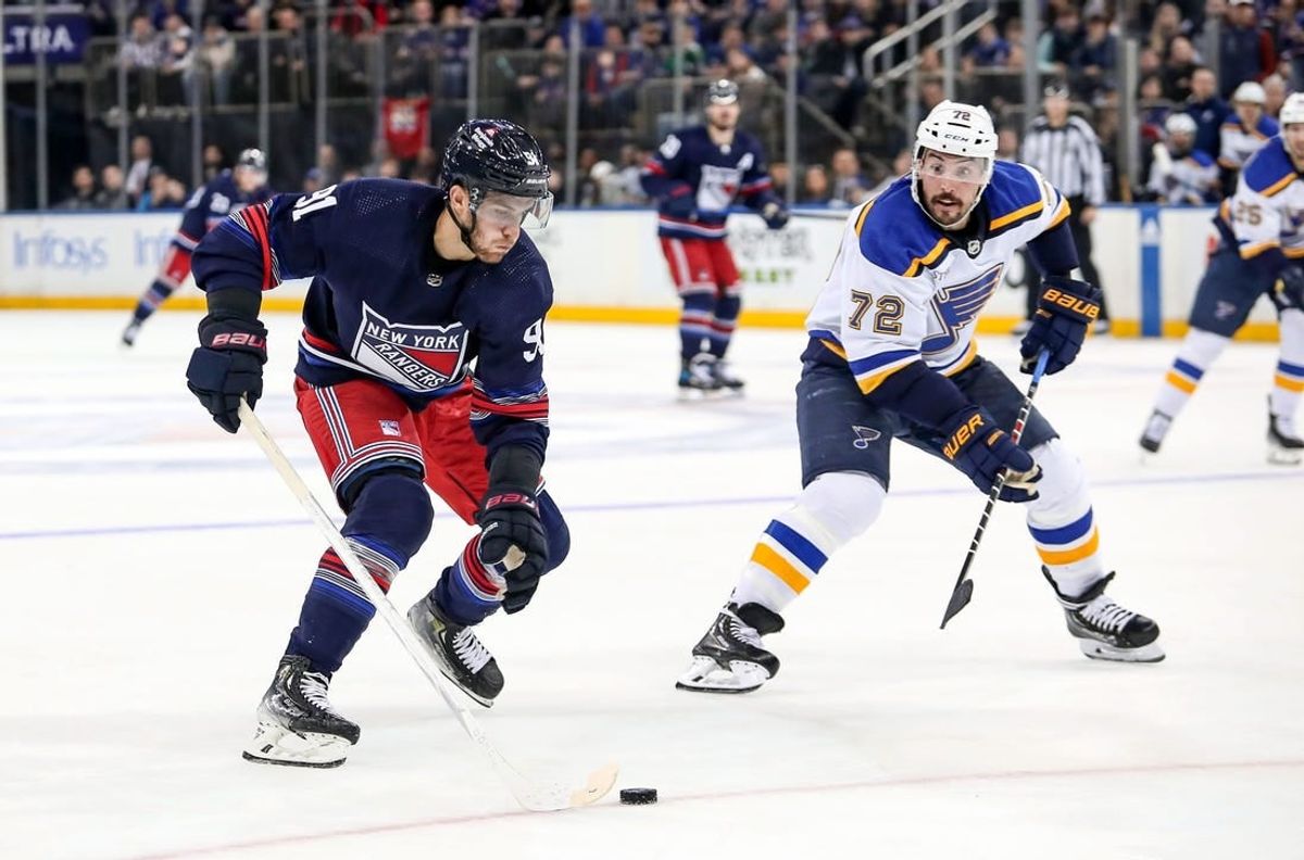 Mar 9, 2024; New York, New York, USA; New York Rangers center Alex Wennberg (91) skates in with the puck against St. Louis Blues defenseman Justin Faulk (72) who was called for hooking during the second period at Madison Square Garden.