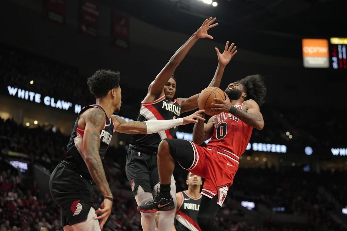 Jan 28, 2024; Portland, Oregon, USA; Chicago Bulls point guard Coby White (0) drives to the basket as he is fouled by Portland Trail Blazers shooting guard Anfernee Simons (1, left) during the first half at Moda Center.