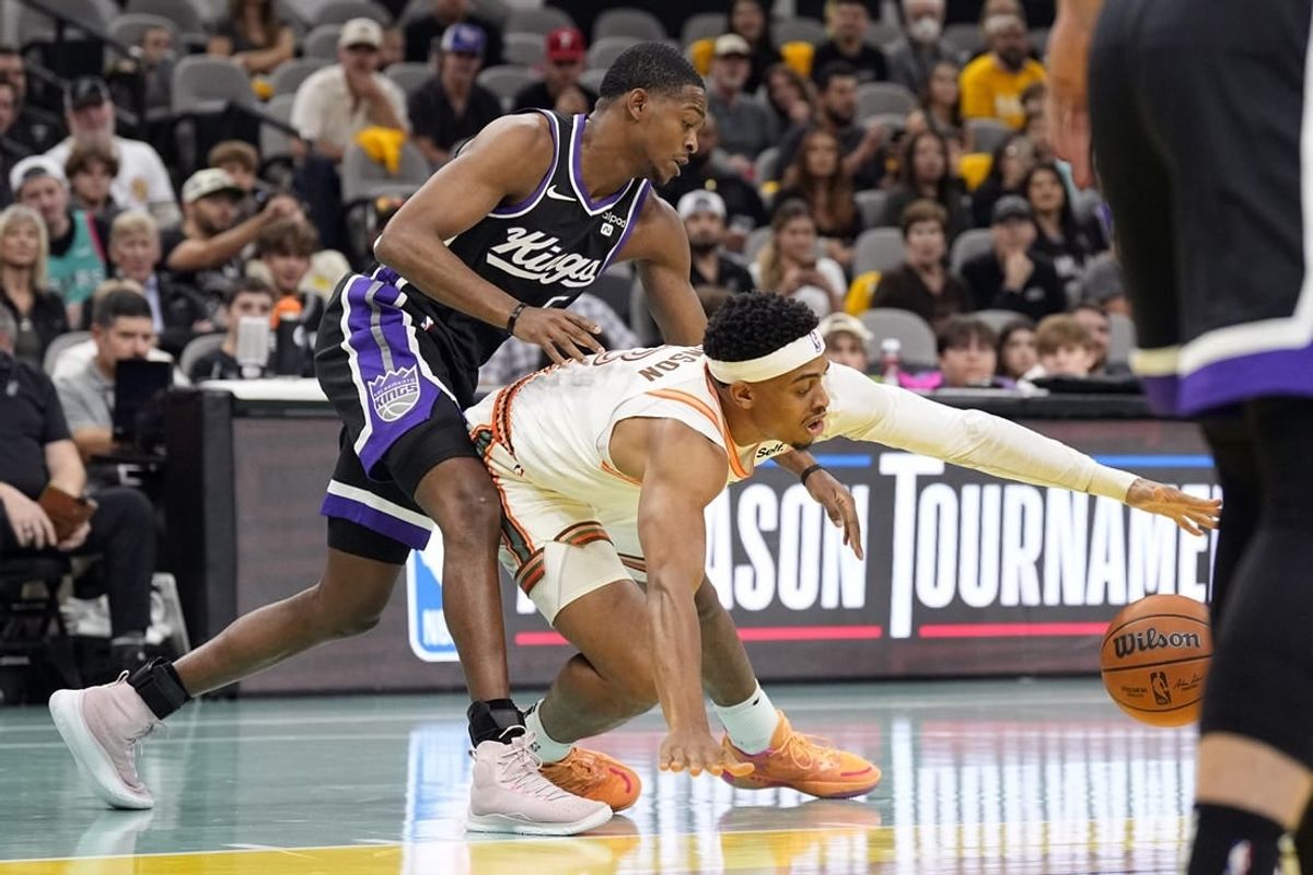 Nov 17, 2023; San Antonio, Texas, USA; Sacramento Kings guard De'Aaron Fox (5) and and San Antonio Spurs forward Keldon Johnson (3) battle for the loose ball during the first half at Frost Bank Center.