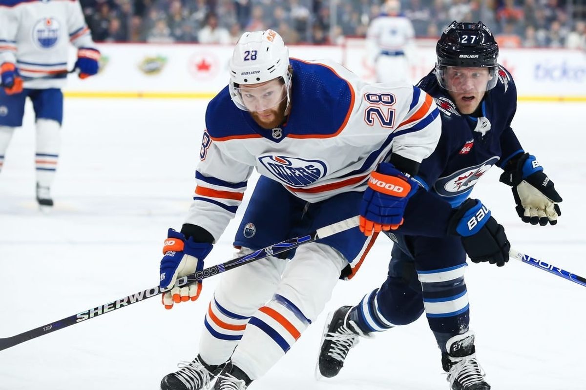 Nov 30, 2023; Winnipeg, Manitoba, CAN; Edmonton Oilers forward Connor Brown (28) jostles for position with Winnipeg Jets forward Nikolaj Ehlers (27) during the first period at Canada Life Centre.