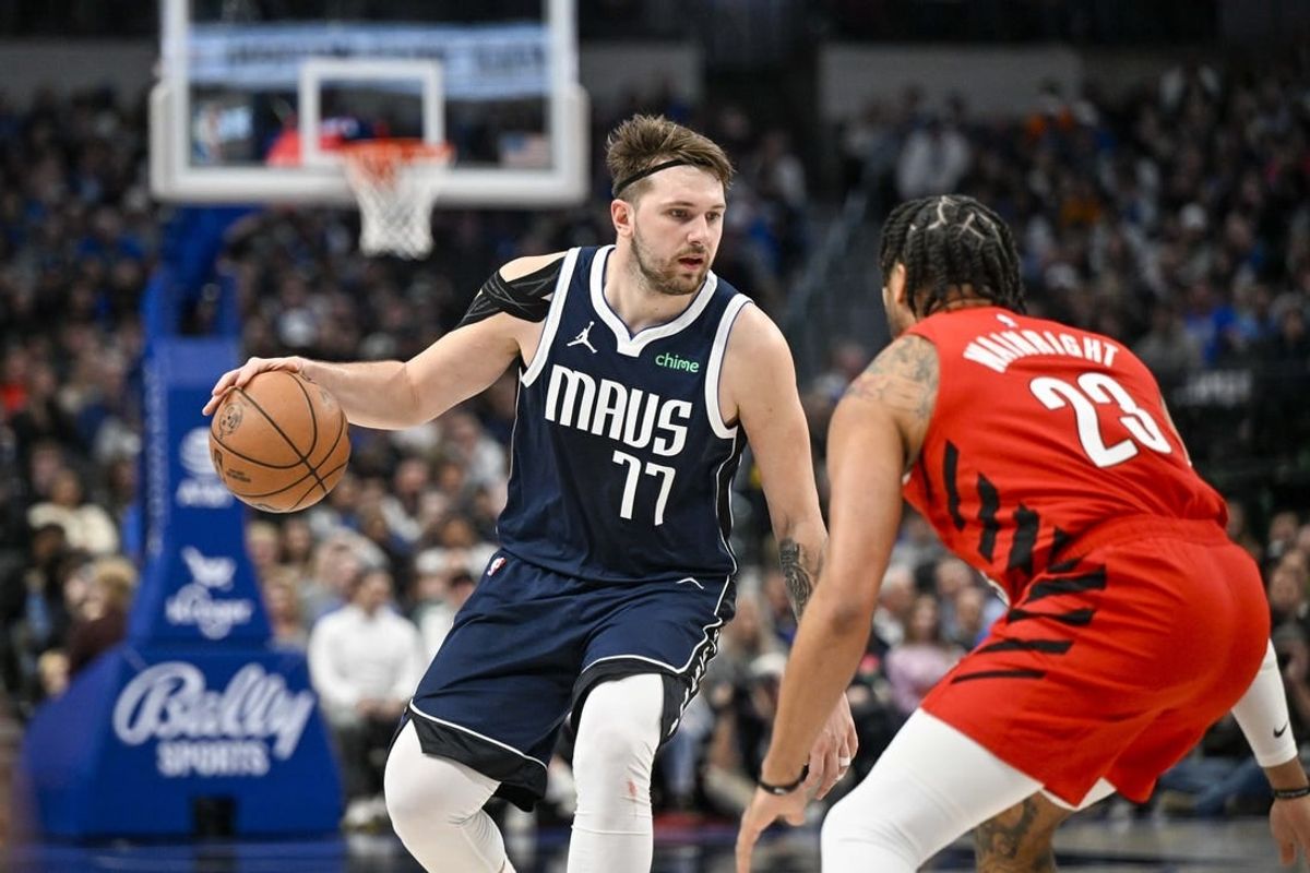 Jan 3, 2024; Dallas, Texas, USA; Dallas Mavericks guard Luka Doncic (77) looks to move the ball past Portland Trail Blazers forward Ish Wainright (23) during the second half at the American Airlines Center.