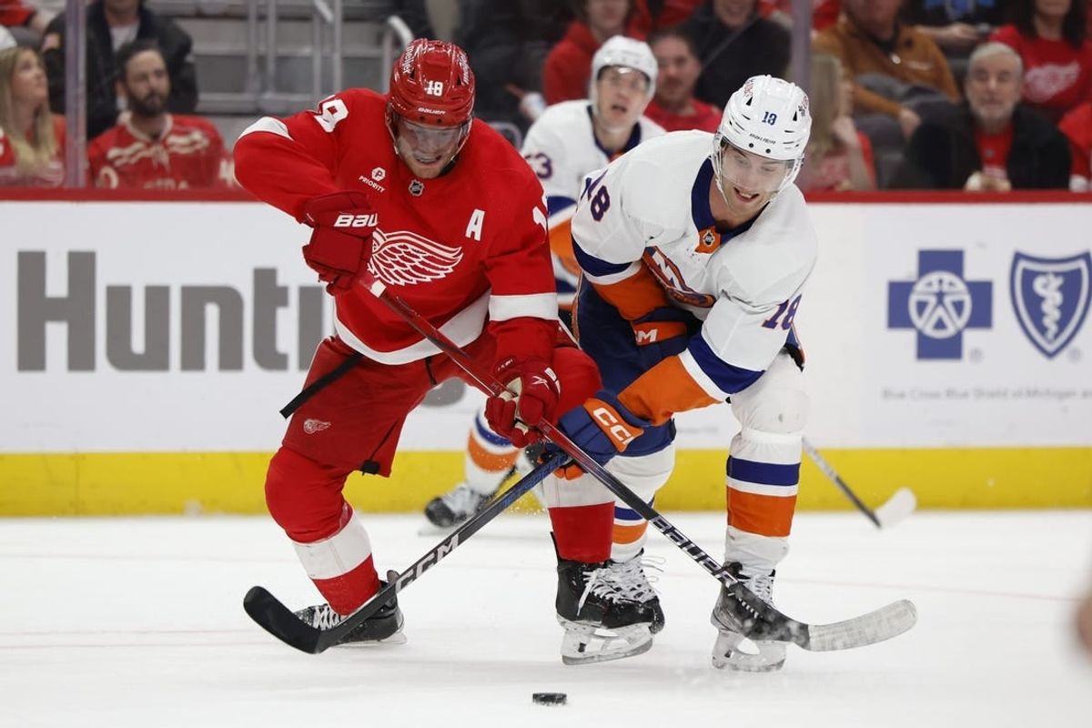 Feb 29, 2024; Detroit, Michigan, USA;  Detroit Red Wings center Andrew Copp (18) and New York Islanders left wing Pierre Engvall (18) battle for the puck in the third period at Little Caesars Arena.