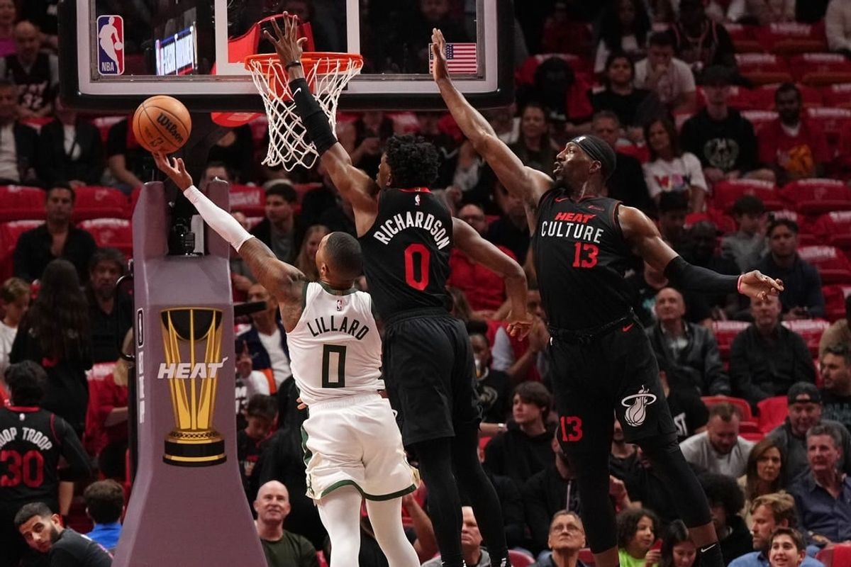 Nov 28, 2023; Miami, Florida, USA; Milwaukee Bucks guard Damian Lillard (0) puts up a shot against Miami Heat guard Josh Richardson (0) during the first half at Kaseya Center.