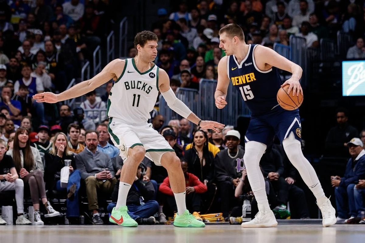 Jan 29, 2024; Denver, Colorado, USA; Denver Nuggets center Nikola Jokic (15) controls the ball as Milwaukee Bucks center Brook Lopez (11) guards in the second quarter at Ball Arena.