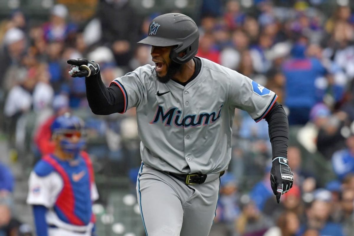 Apr 20, 2024; Chicago, Illinois, USA; Miami Marlins outfielder Bryan De La Cruz (14) points in the dugout after hitting a two-run home run during the ninth inning against the Chicago Cubs at Wrigley Field.