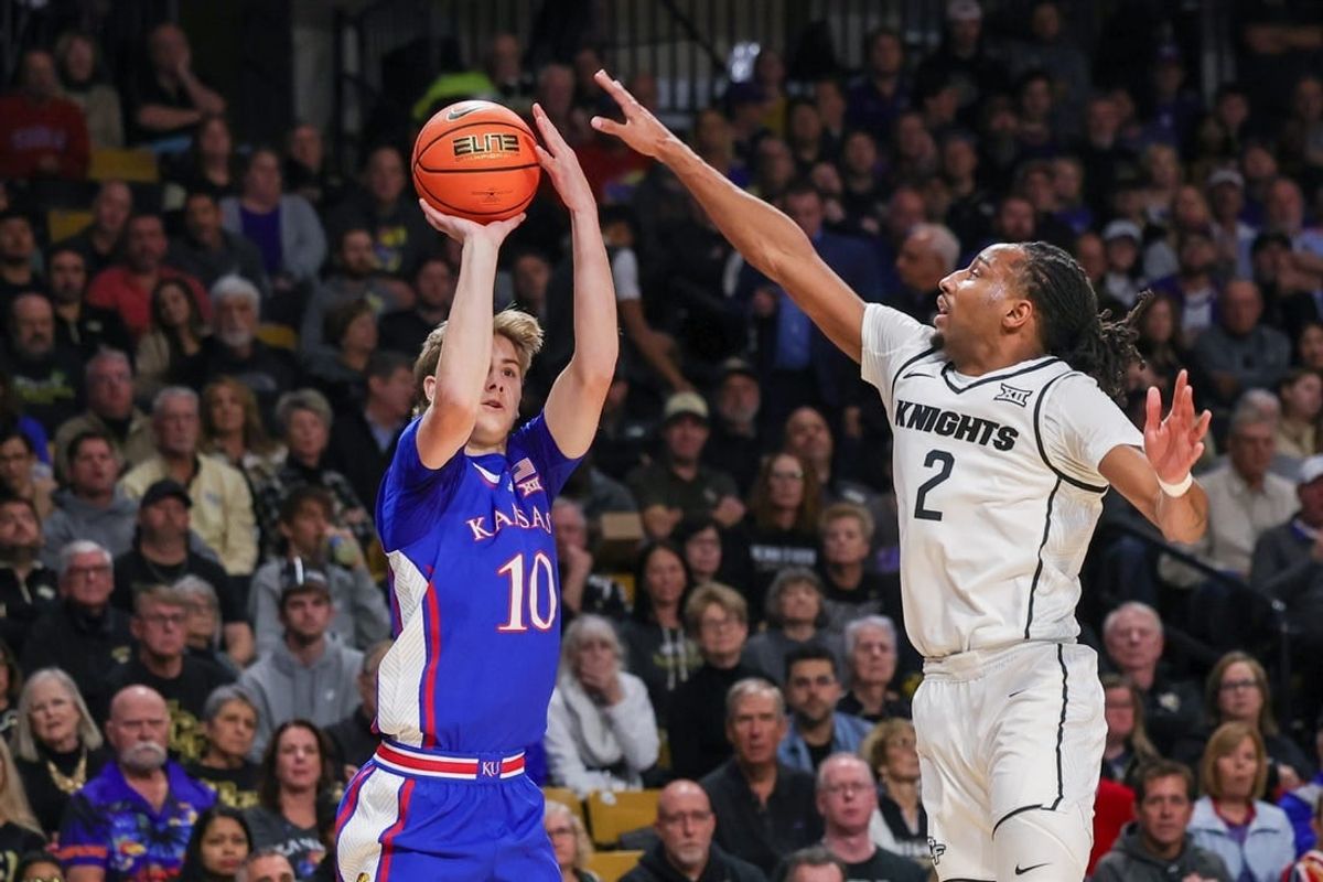 Jan 10, 2024; Orlando, Florida, USA; Kansas Jayhawks guard Johnny Furphy (10) shoots a three point basket against UCF Knights guard Shemarri Allen (2) during the first period against the UCF Knights at Addition Financial Arena.