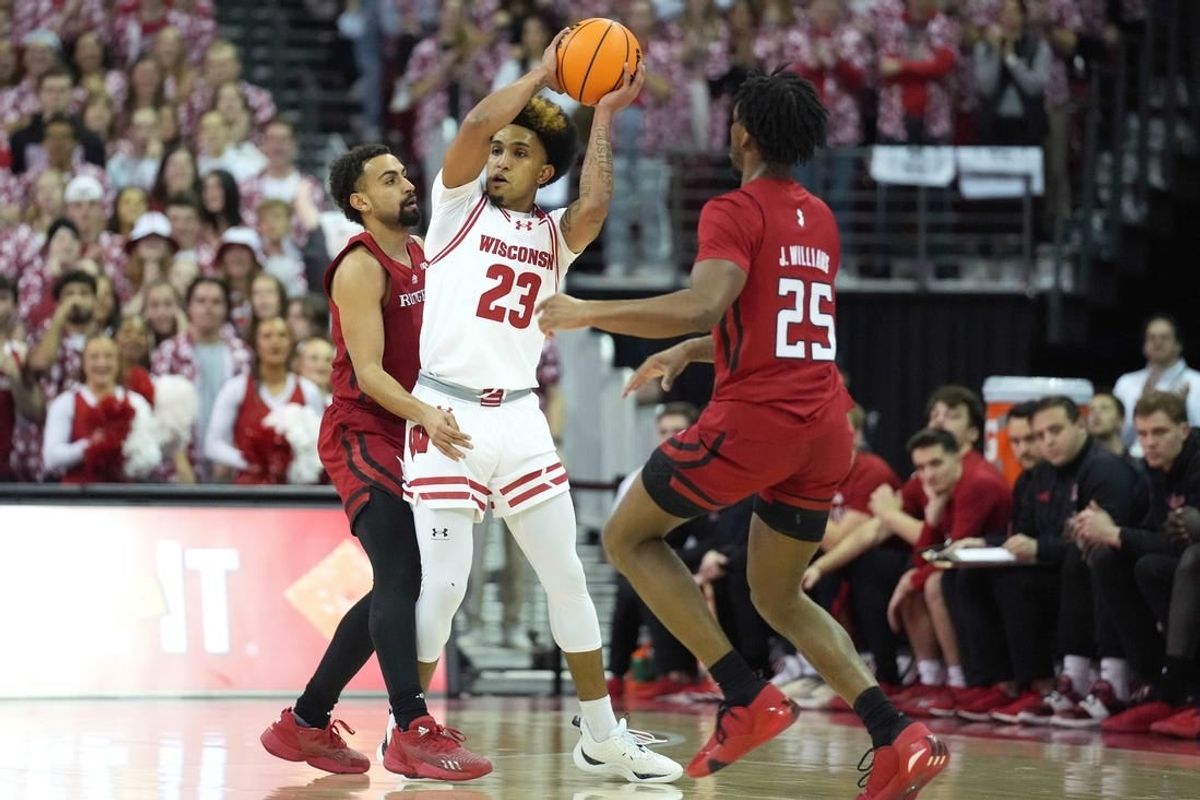 Mar 7, 2024; Madison, Wisconsin, USA;  Wisconsin Badgers guard Chucky Hepburn (23) looks to pass the ball against Rutgers Scarlet Knights guard Noah Fernandes (2) and Rutgers Scarlet Knights guard Jeremiah Williams (25) during the first half at Kohl Center.