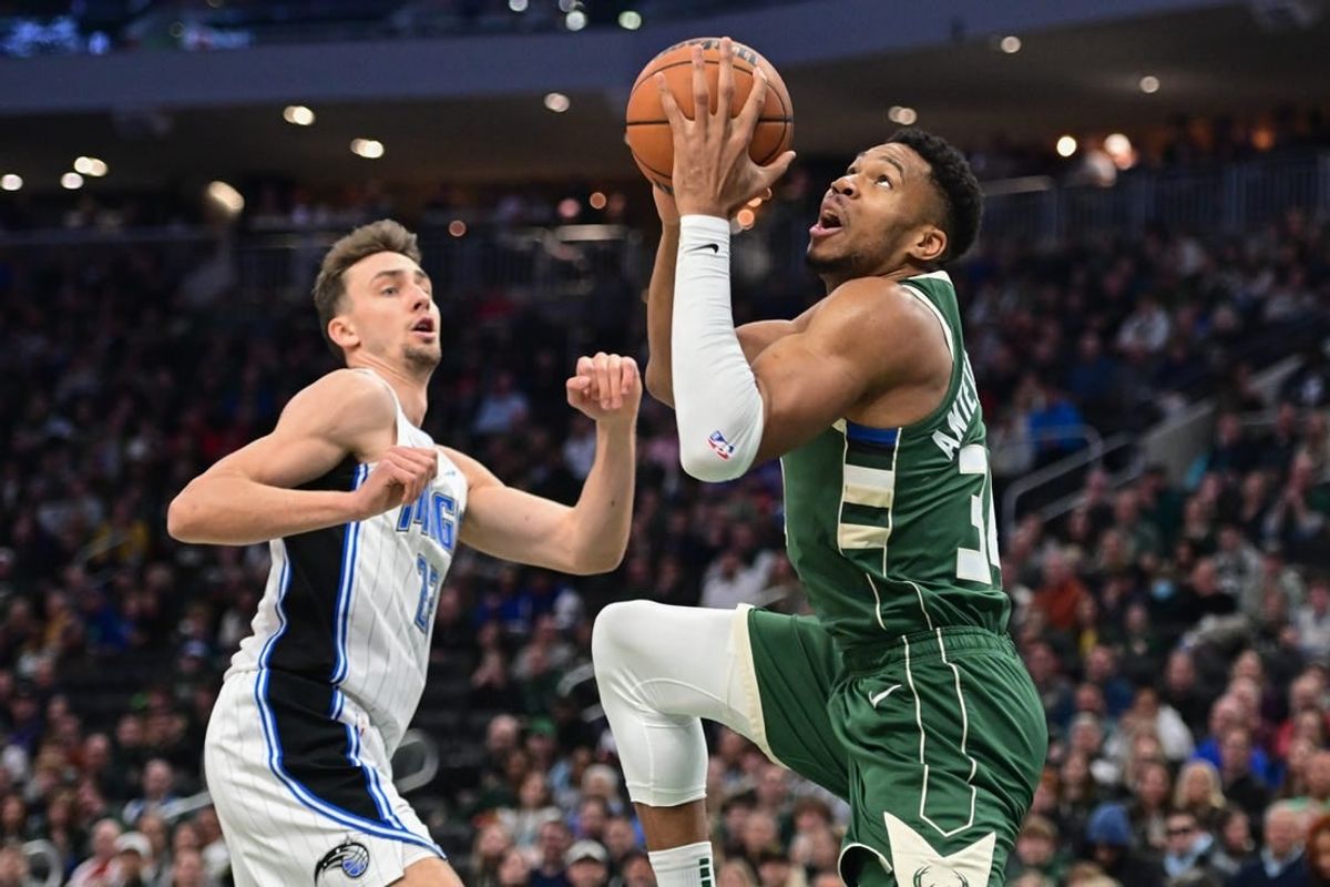 Dec 21, 2023; Milwaukee, Wisconsin, USA; Milwaukee Bucks forward Giannis Antetokounmpo (34) takes a shot against Orlando Magic forward Franz Wagner (22) in the first quarter at Fiserv Forum.