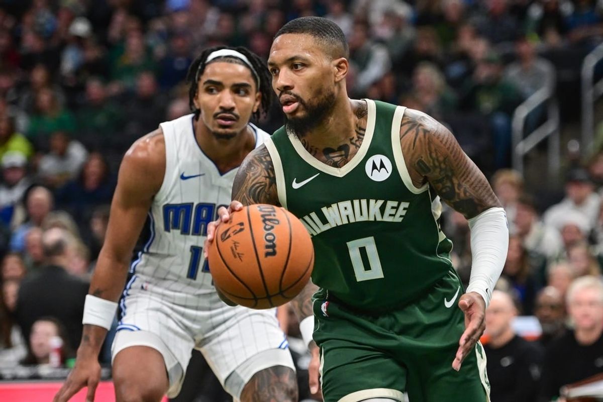 Dec 21, 2023; Milwaukee, Wisconsin, USA;  Milwaukee Bucks guard Damian Lillard (0) drives past Orlando Magic guard Gary Harris (14) in the fourth quarter at Fiserv Forum.