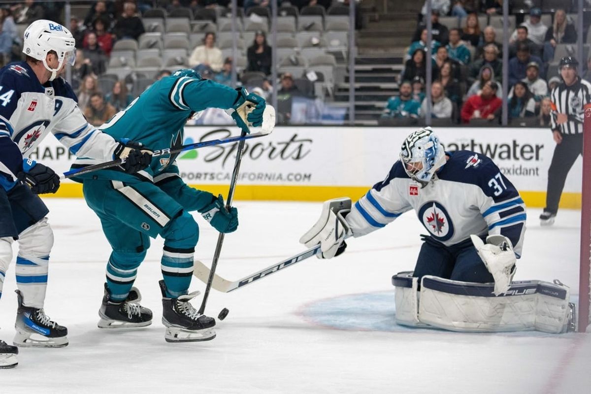Jan 4, 2024; San Jose, California, USA; Winnipeg Jets goaltender Connor Hellebuyck (37) defends against San Jose Sharks defenseman Mario Ferraro (38) during the second period at SAP Center at San Jose.