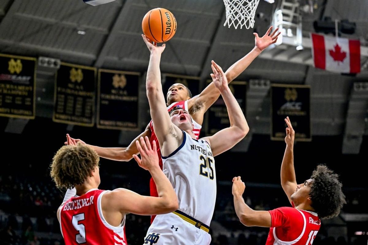Dec 22, 2023; South Bend, Indiana, USA; Notre Dame Fighting Irish forward Matt Zona (25) goes up for a shot as Marist Red Foxes forward Jaden Daughtry (11) prepares to block in the first half at the Purcell Pavilion.