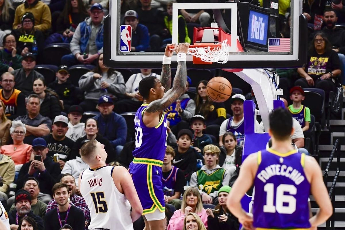 Jan 10, 2024; Salt Lake City, Utah, USA; Utah Jazz forward/center John Collins (20) dunks over Denver Nuggets center Nikola Jokic (15) during the first half at the Delta Center.