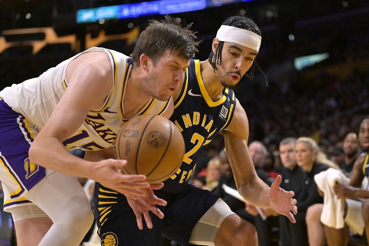 Mar 24, 2024; Los Angeles, California, USA;   Los Angeles Lakers guard Austin Reaves (15) and Indiana Pacers guard Andrew Nembhard (2) go for the ball in the second half at Crypto.com Arena.