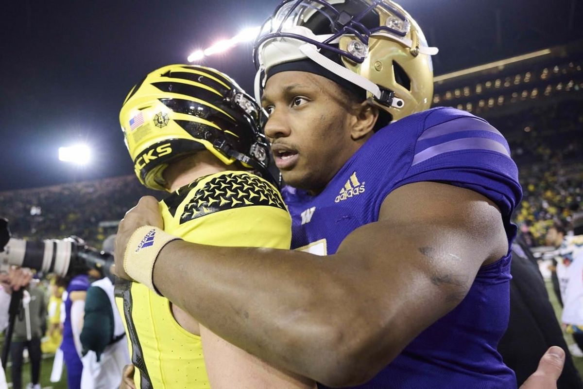 Nov 12, 2022; Eugene, Oregon, USA; Washington Huskies quarterback Michael Penix Jr. (9) embraces Oregon Ducks quarterback Bo Nix (10) after a game at Autzen Stadium. The Huskies won the game 37-34.