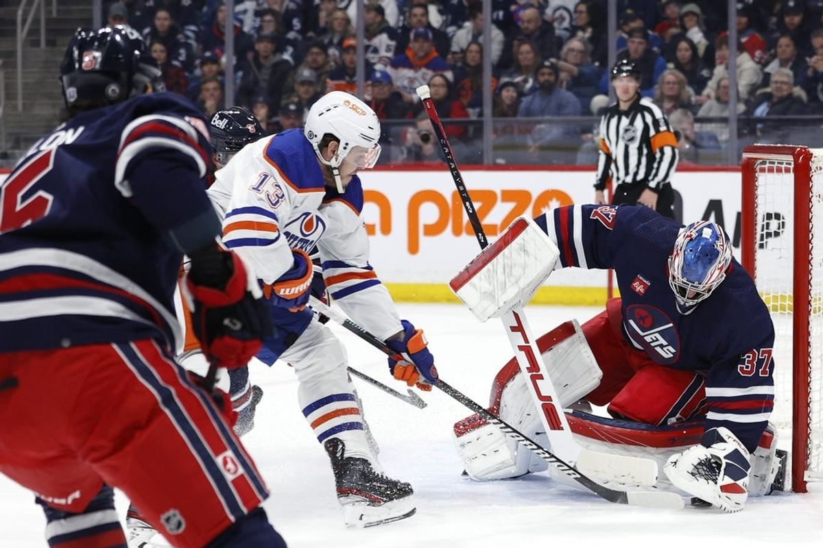 Mar 26, 2024; Winnipeg, Manitoba, CAN; Winnipeg Jets goaltender Connor Hellebuyck (37) covers up a rebound from Edmonton Oilers center Mattias Janmark (13) in the first period at Canada Life Centre.
