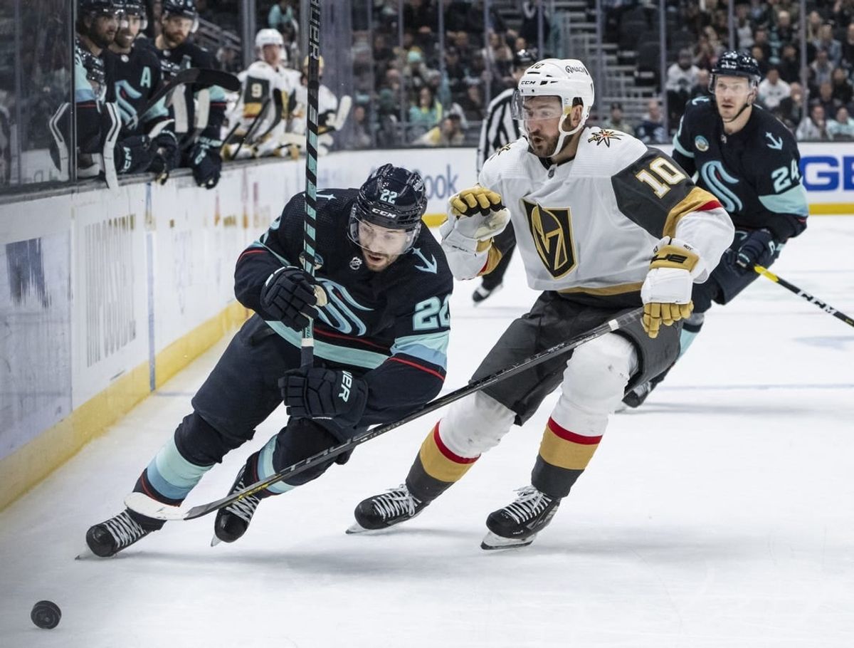 Mar 12, 2024; Seattle, Washington, USA; Seattle Kraken forward Oliver Bjorkstrand (22) and Vegas Golden Knights forward Nicolas Roy (10) battle for the puck during overtime at Climate Pledge Arena.