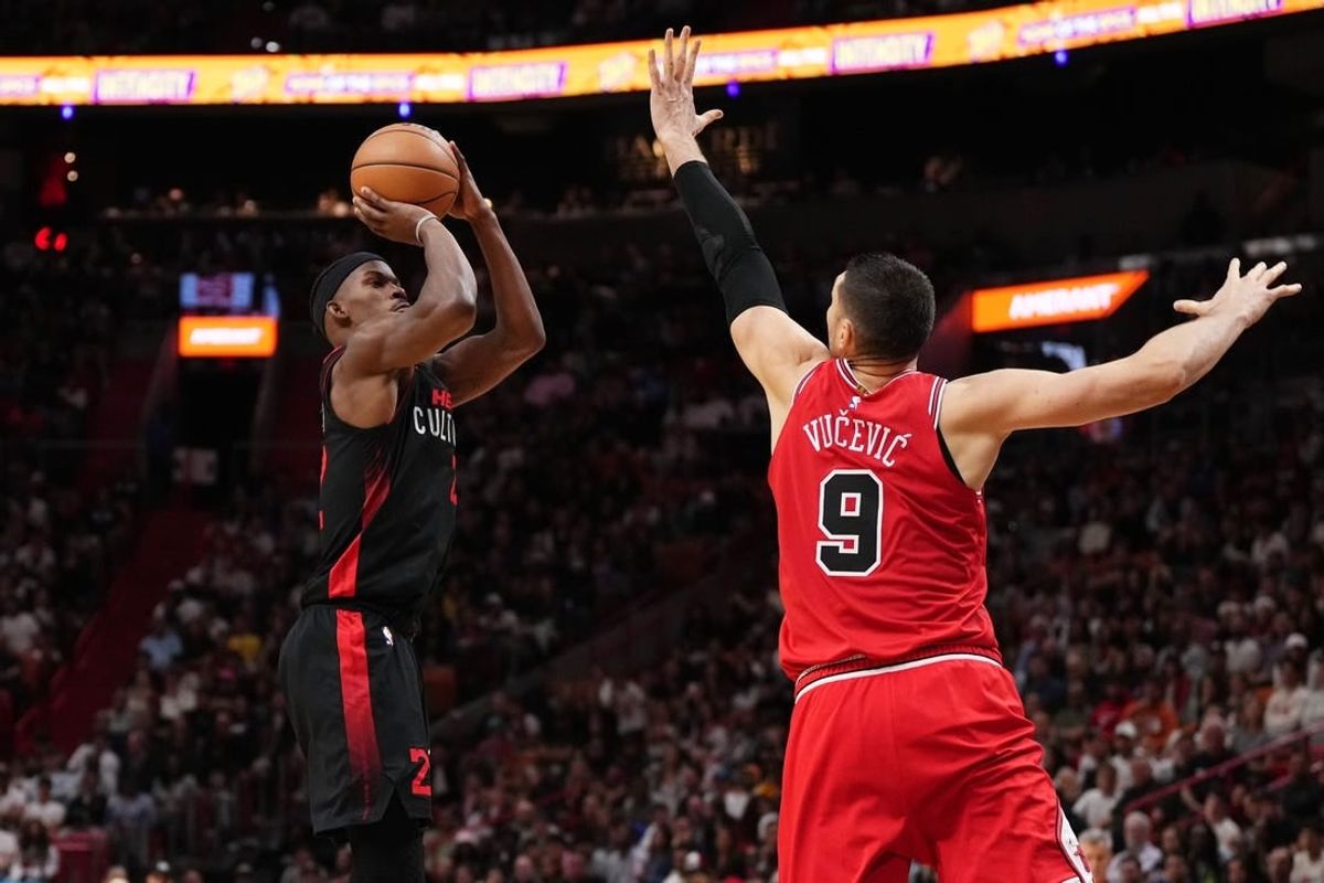 Dec 16, 2023; Miami, Florida, USA; Miami Heat forward Jimmy Butler (22) shoots over Chicago Bulls center Nikola Vucevic (9) during the second half at Kaseya Center.
