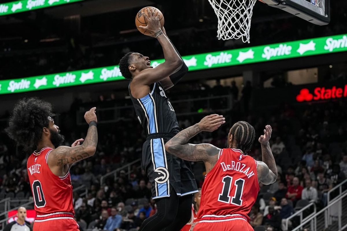 Feb 12, 2024; Atlanta, Georgia, USA; Atlanta Hawks forward Onyeka Okongwu (17) scores a basket over Chicago Bulls forward DeMar DeRozan (11) during the first half at State Farm Arena.