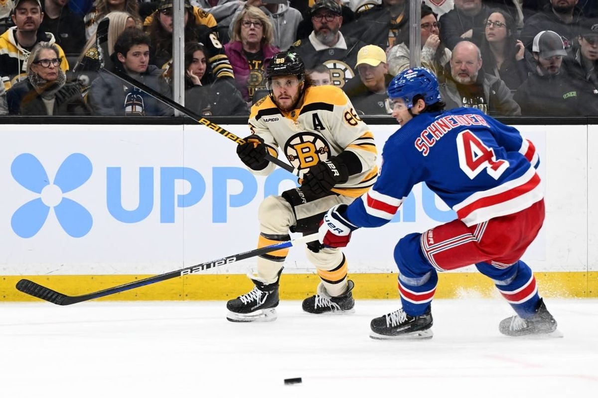Mar 21, 2024; Boston, Massachusetts, USA; Boston Bruins right wing David Pastrnak (88) shoots the puck in front of New York Rangers defenseman Braden Schneider (4) during the first period at the TD Garden.