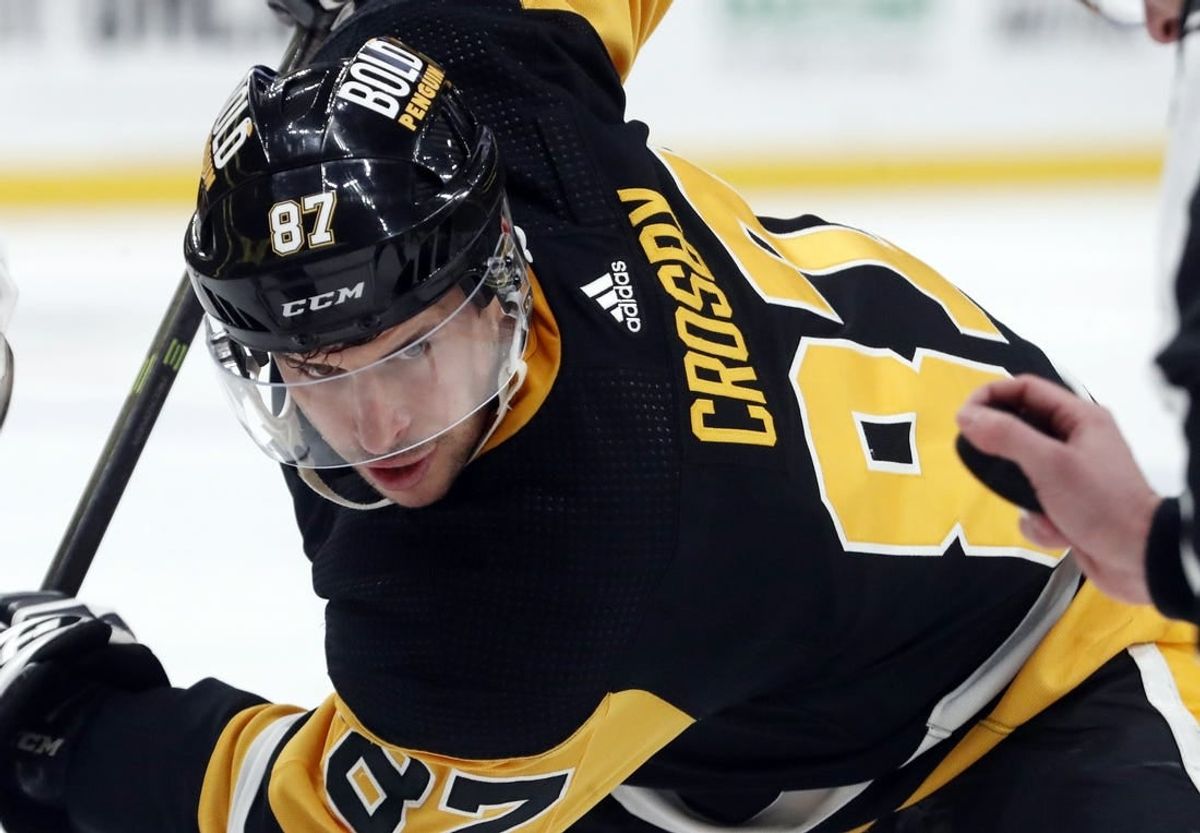 Dec 30, 2023; Pittsburgh, Pennsylvania, USA; Pittsburgh Penguins center Sidney Crosby (87) eyes the puck on a face-off against the St. Louis Blues during the first period at PPG Paints Arena.
