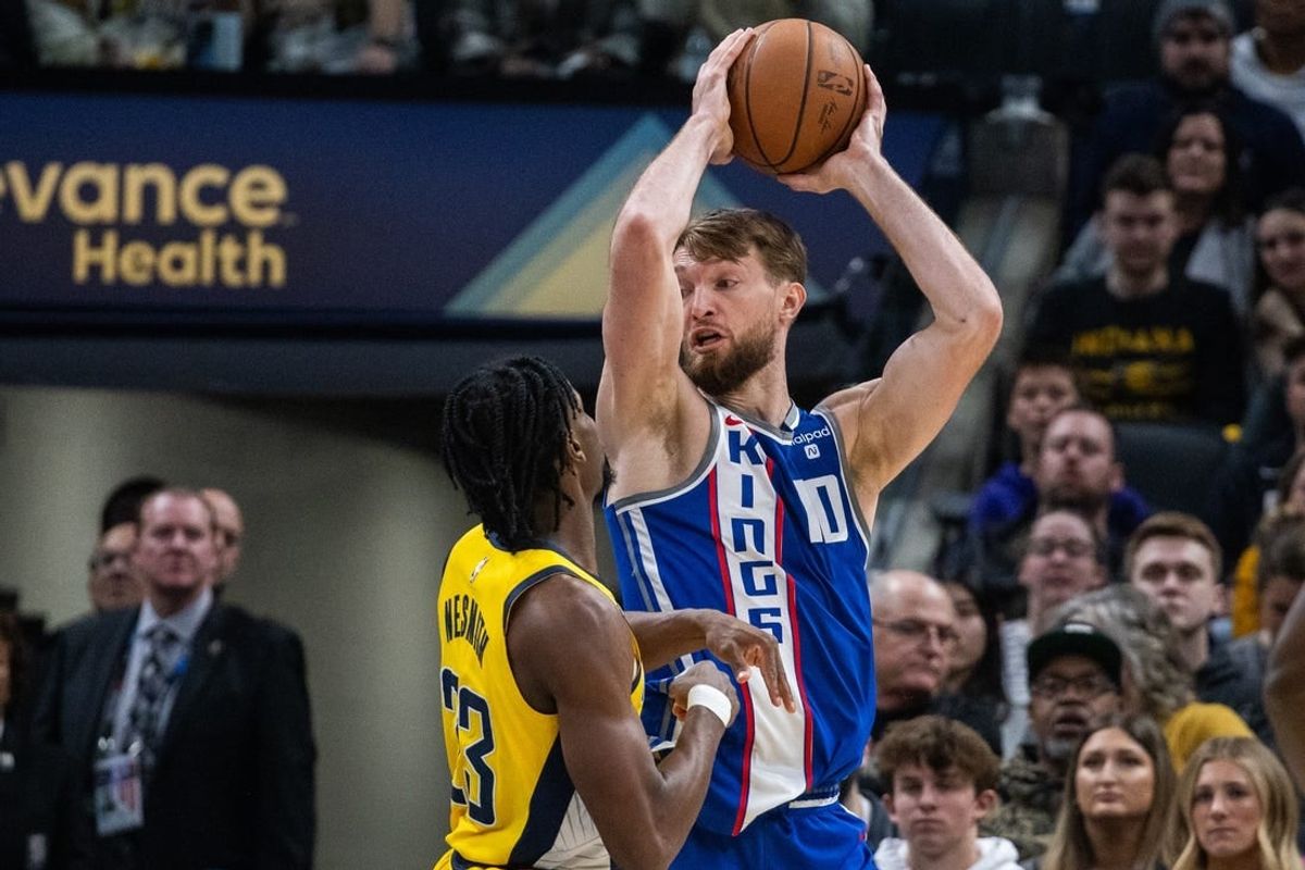 Feb 2, 2024; Indianapolis, Indiana, USA; Sacramento Kings forward Domantas Sabonis (10) holds the ball while  Indiana Pacers forward Aaron Nesmith (23) defends in the first half at Gainbridge Fieldhouse.