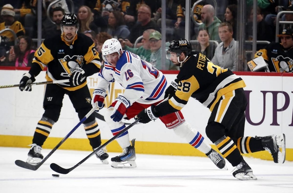 Mar 16, 2024; Pittsburgh, Pennsylvania, USA;  Pittsburgh Penguins defenseman Marcus Pettersson (28) moves the puck against New York Rangers left wing Jimmy Vesey (26) during the second period at PPG Paints Arena.