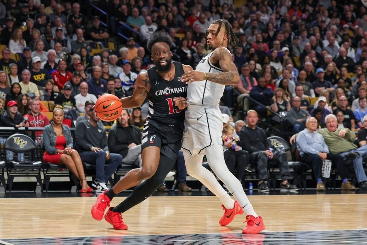 Feb 17, 2024; Orlando, Florida, USA; Cincinnati Bearcats forward John Newman III (15) drives around UCF Knights guard Antwann Jones (1) during the first half at Addition Financial Arena.