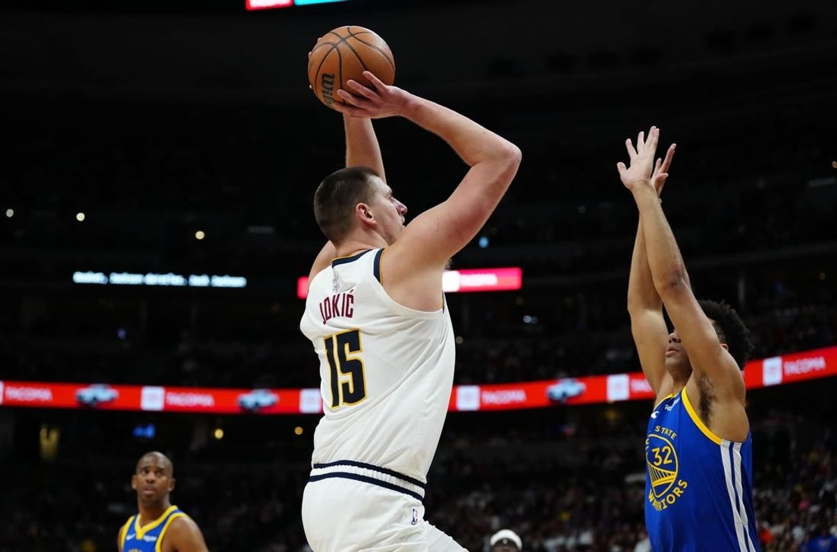Dec 25, 2023; Denver, Colorado, USA; Denver Nuggets center Nikola Jokic (15) prepares to shoot over Golden State Warriors forward Trayce Jackson-Davis (32) in the second half at Ball Arena.