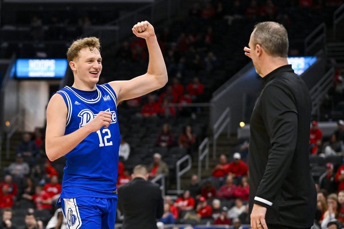 Mar 5, 2023; St. Louis, MO, USA; Drake Bulldogs guard Tucker DeVries (12) celebrates with head coach Darian DeVries during the second half against the Bradley Braves in the finals of the Missouri Valley Conference Tournament at Enterprise Center.